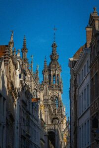 Stunning low-angle view of Brussels Town Hall's gothic facade against a clear blue sky.